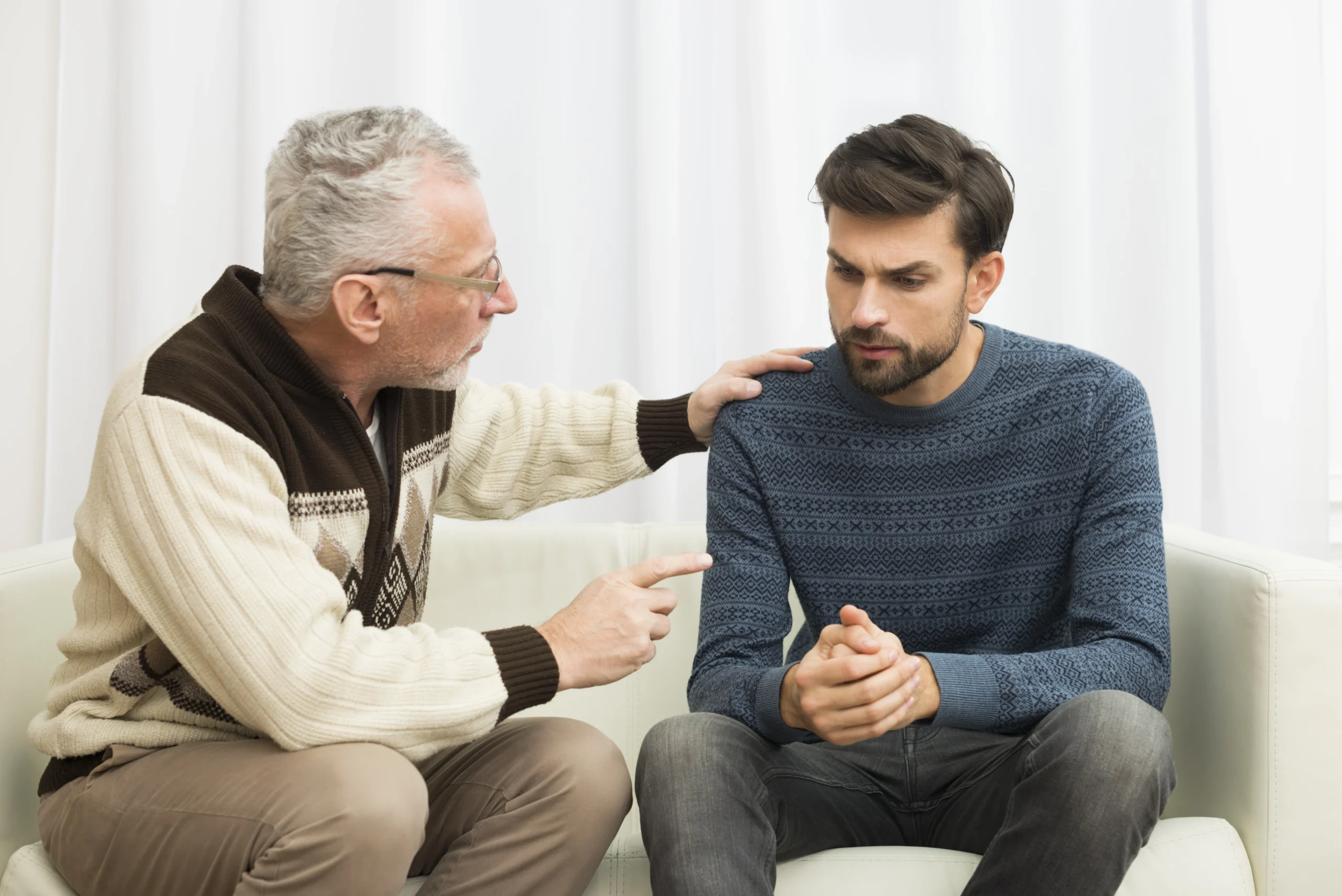 An older man offering advice to a young man, symbolizing support for someone with what is high functioning depression, emphasizing the importance of communication and emotional support.