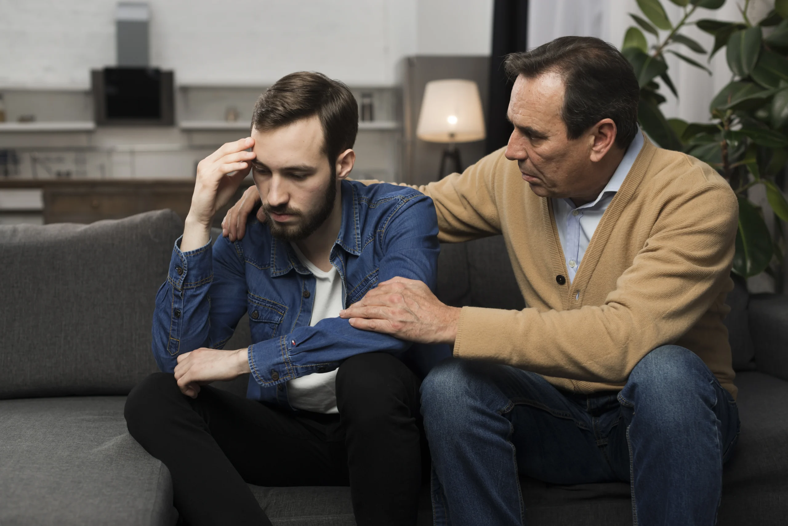 Father comforting his son, showing support during a mental health struggle, emphasizing the need to address men's mental health in Men's Mental Health Month.