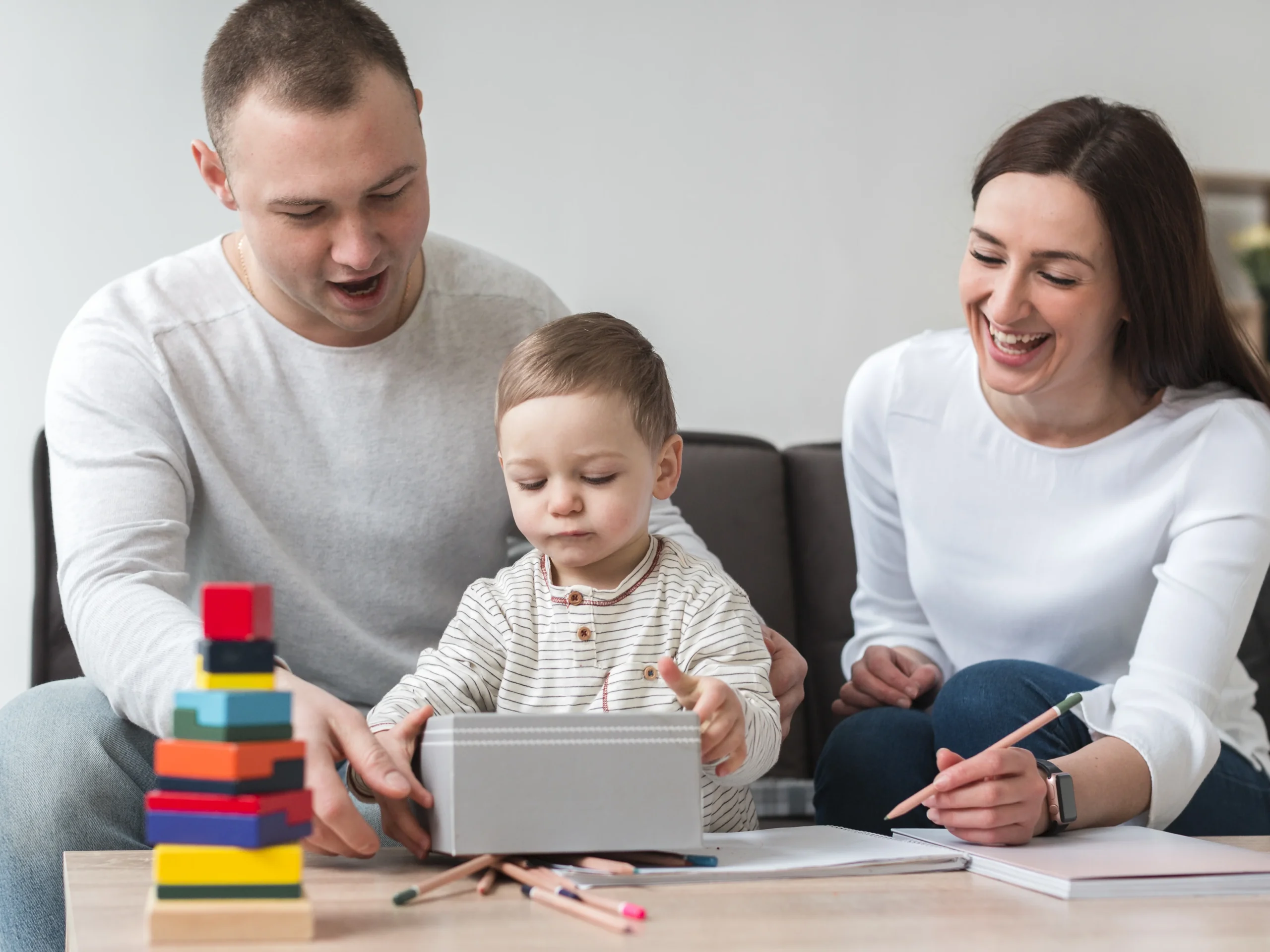 Parents helping their child explore developmental activities at home, supporting key growth milestones parents should know like motor and cognitive skills."