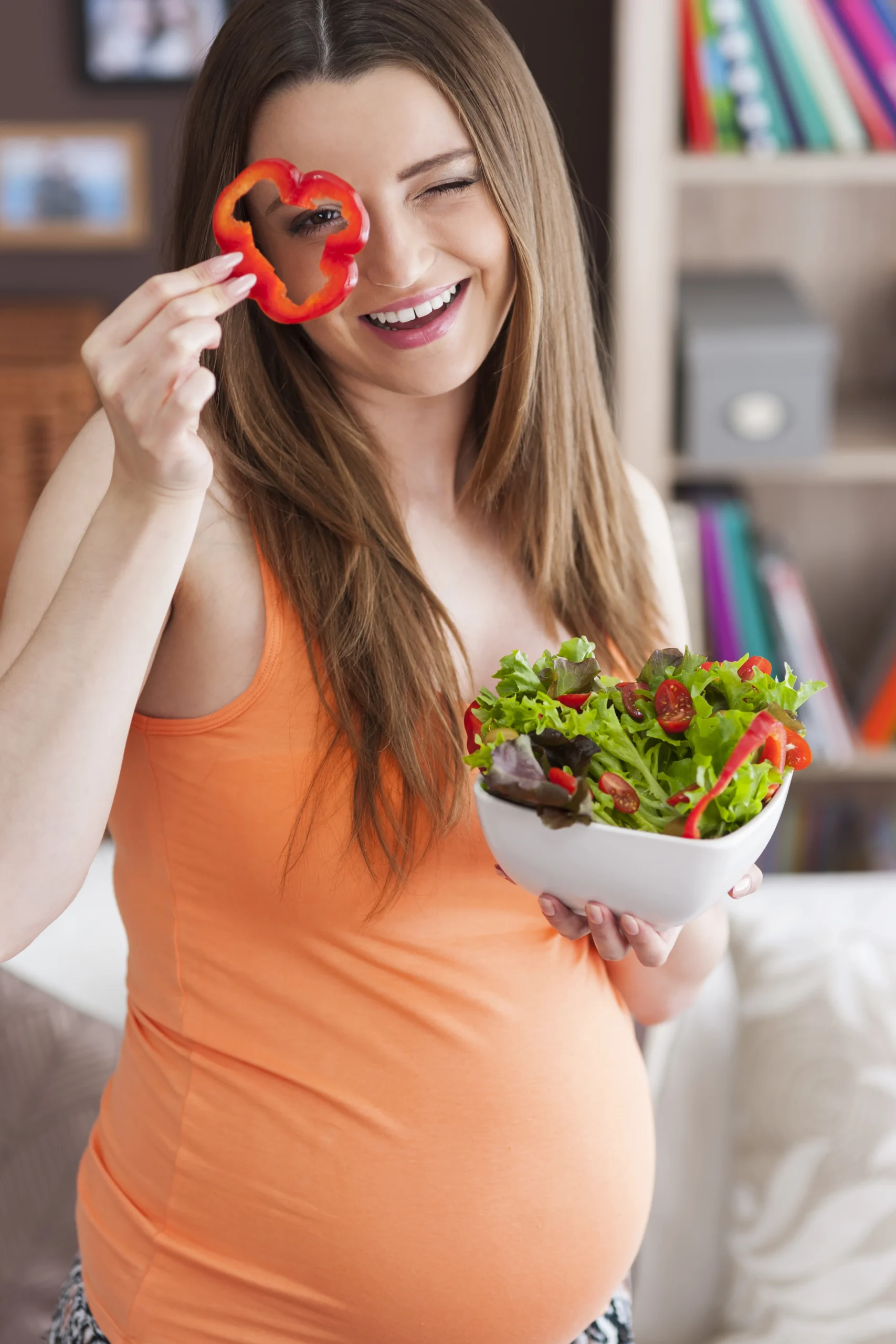 Pregnant woman enjoying a healthy salad, emphasizing the importance of pregnancy nutrition essentials for women for both maternal health and baby development.