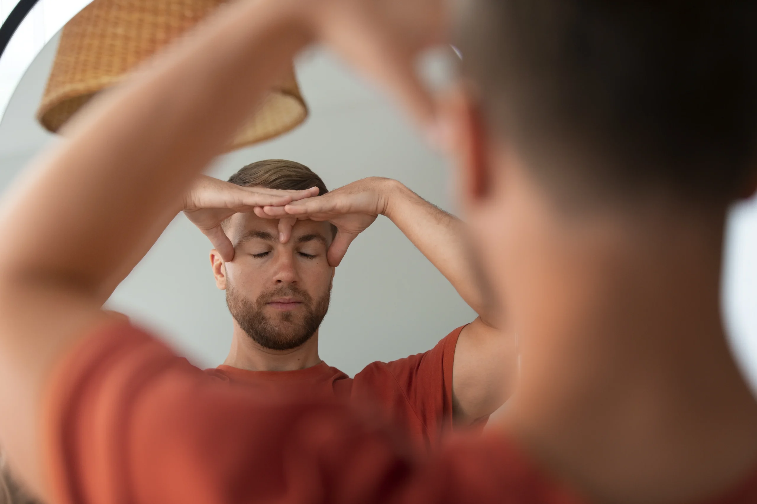 Man practicing mindfulness and facial yoga as part of self-care, illustrating what are some issues that affect spiritual health such as stress and mental tension