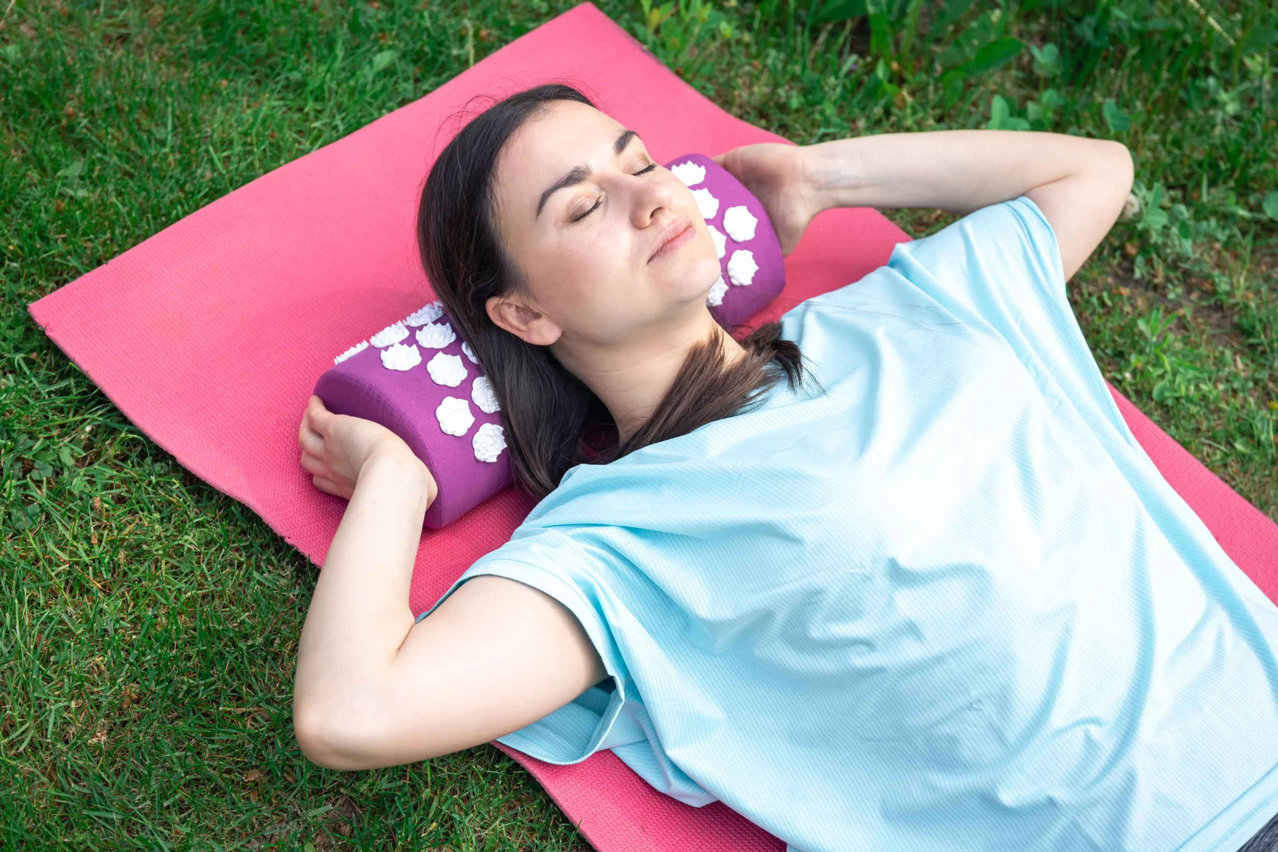 A woman using an acupressure mat to relax, demonstrating how to listen to your body and recognize the early signs your body needs rest through self-care and relaxation techniques.