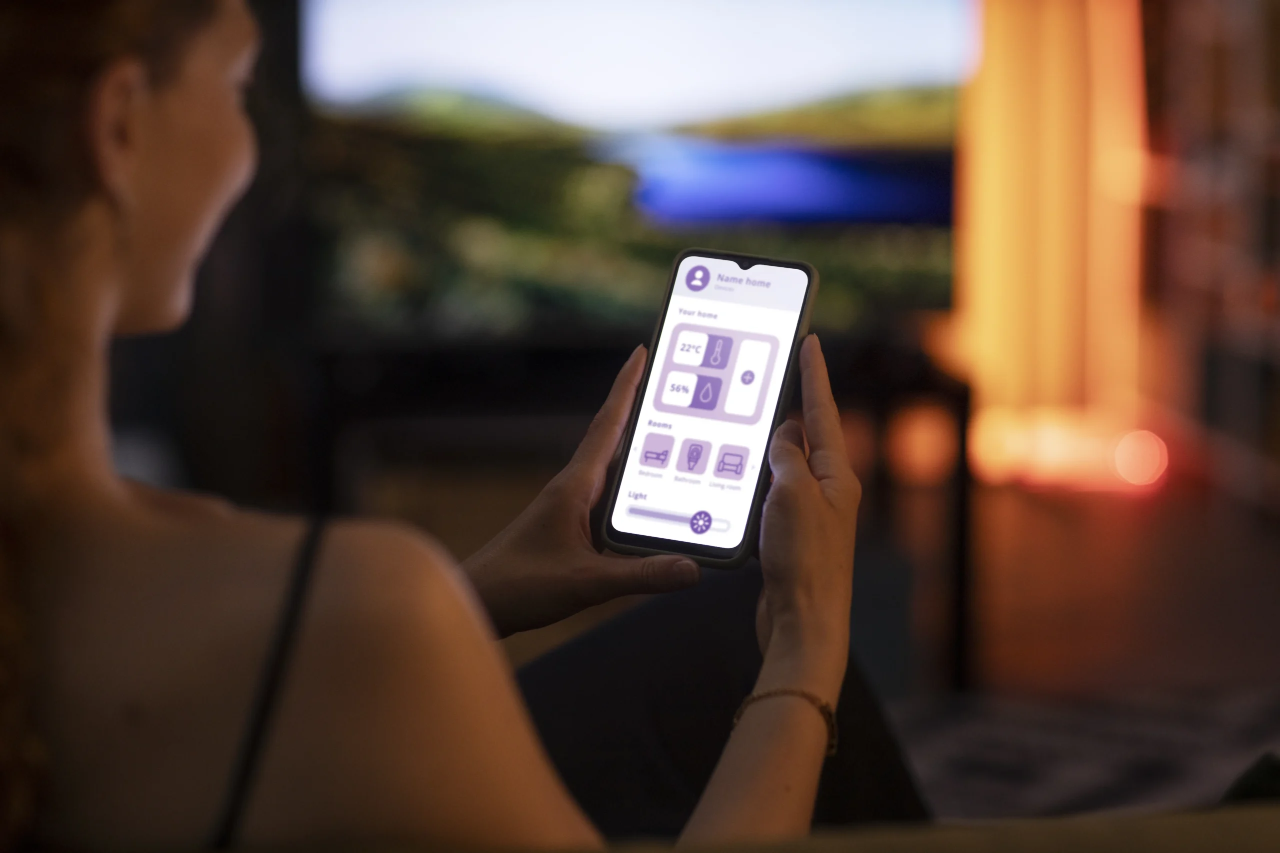 A person using a smartphone app to control home settings, including temperature and lighting. This highlights how digital tools, like digital mental health apps, are enhancing comfort and well-being.