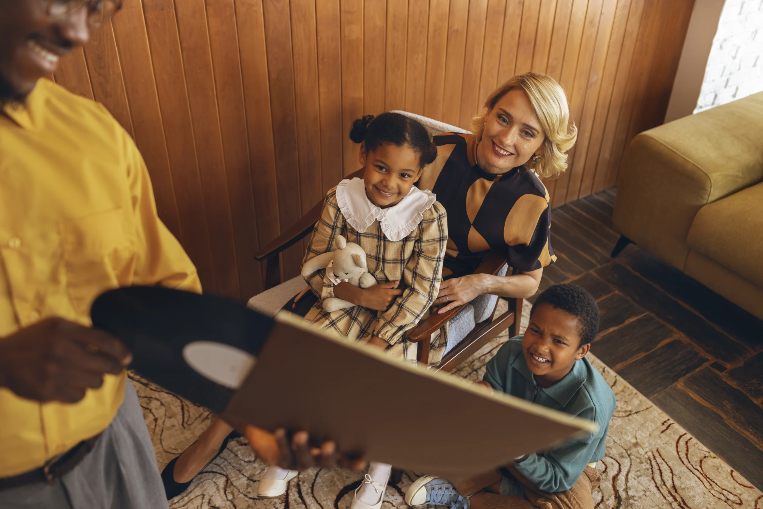 A happy family bonding time with children, promoting kids' mental health through shared moments and laughter, as they enjoy a retro music session together.
