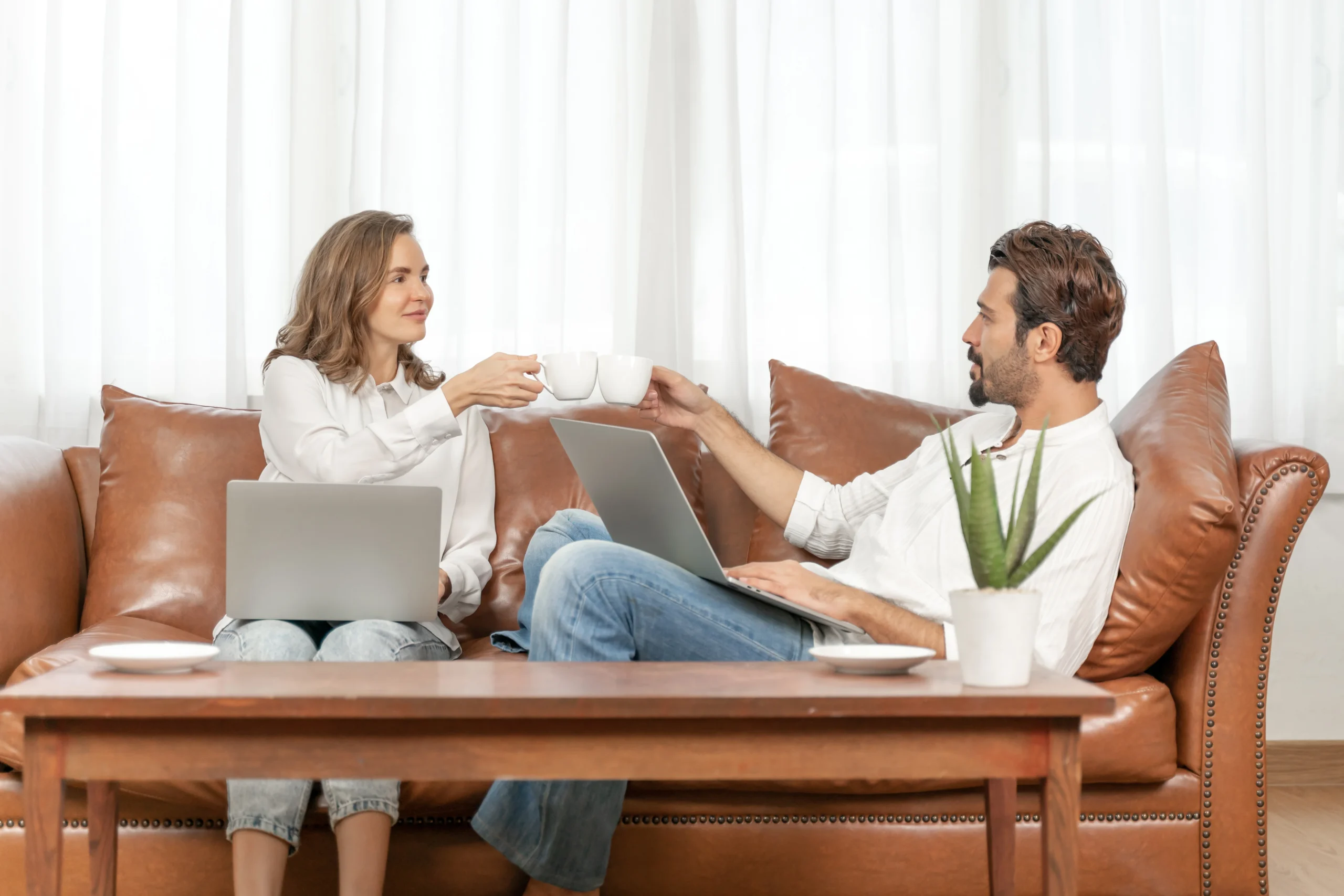 American parent and teenager sitting side‑by‑side on a living room couch in a modern U.S. home, both with phones set aside on the coffee table, making eye contact and having a calm conversation about online life, warm evening lighting, diverse family, realistic lifestyle photography, 16:9, positive and trusting atmosphere.”