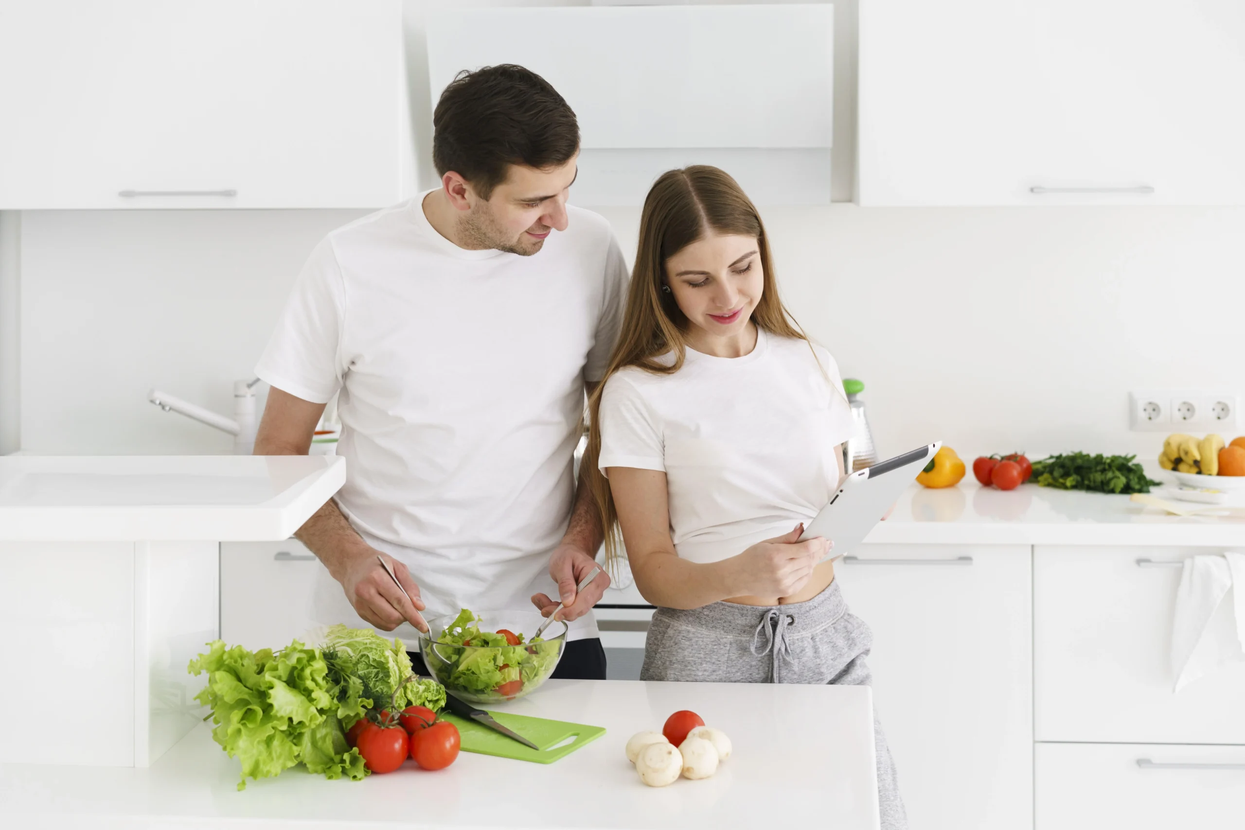 how to have healthy gut bacteria naturally through balanced diet and fresh vegetables shown by couple preparing healthy salad at home